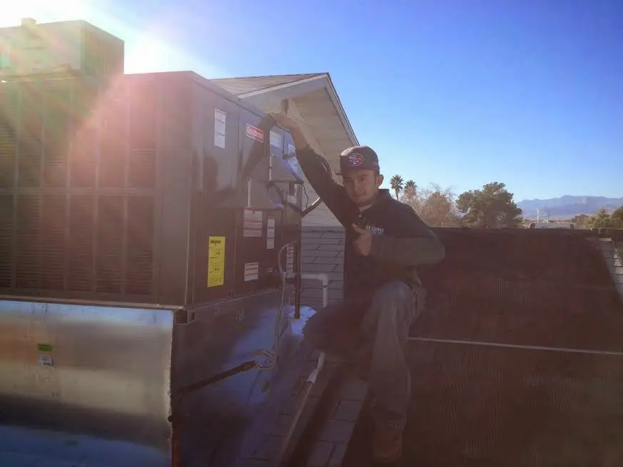 HVAC technician performing HVAC Inspection on a rooftop unit in Frisco